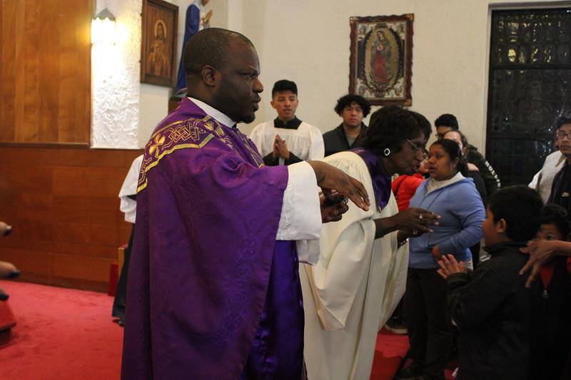 WINSTON-SALEM — Father Moses and Rose Hinson, an extraordinary minister, distribute ash on the foreheads of the congregation. (Photo provided by Gloria Wilson)
