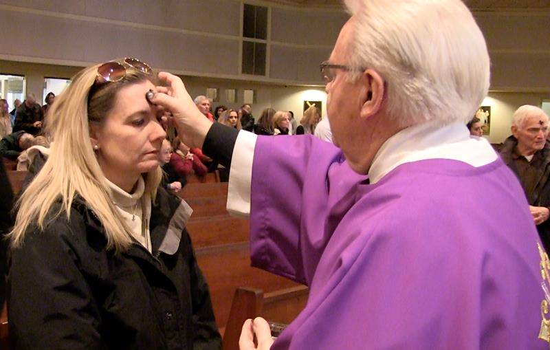 CHARLOTTE — Father Frank O’Rourke, pastor, and Deacon Larry O’Toole distribute ashes at St. Gabriel Church in Charlotte March 6. (Photo by César Hurtado)