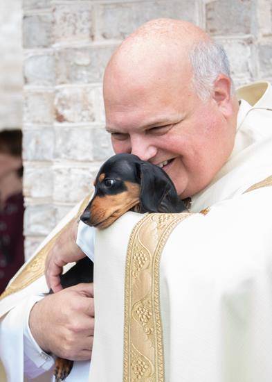 GREENSBORO — Monsignor Anthony Marcaccio with a Miniature Dachshund. (Photos by MaryAnn Luedtke)