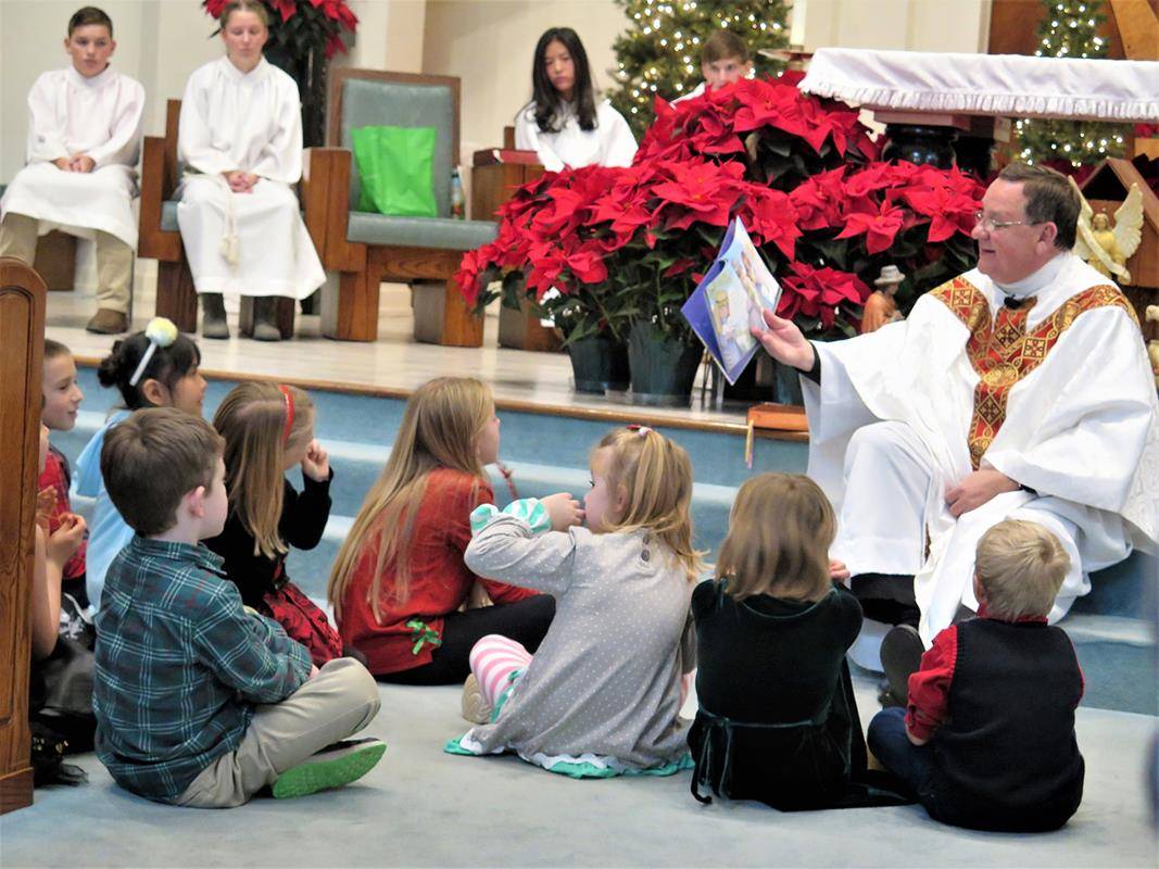 STATESVILLE — During Mass on Christmas Eve at St. Philip the Apostle Church, Father Thomas Kessler, pastor, read the Christmas story to the children in attendance. (Photo provided by Connie Ries)